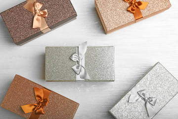 Boxes with Christmas presents on light wooden background