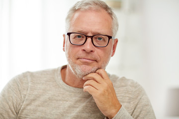 close up of senior man in glasses thinking