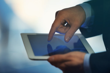 Businessman touching screen of modern tablet, closeup