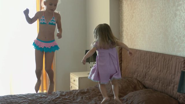 Happy children jumping on the bed and having fun