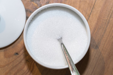 Fototapeta na wymiar White sugar in glass bowl with teaspoon 