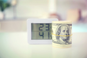 Savings concept. Money and electronic thermometer on table