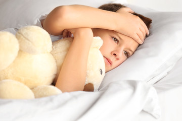 Obraz na płótnie Canvas Small sick boy with Teddy bear in bed