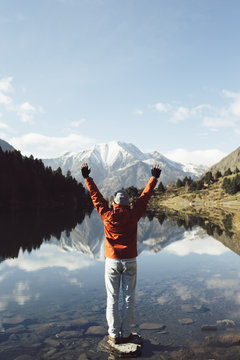 France, Pyrenees, Pic Carlit, hiker raising his arms at mountain lake