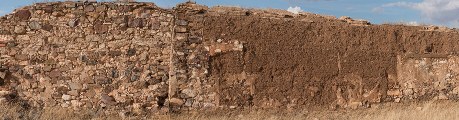 Textured ancient stone and mud wall from a ruined house in Spain