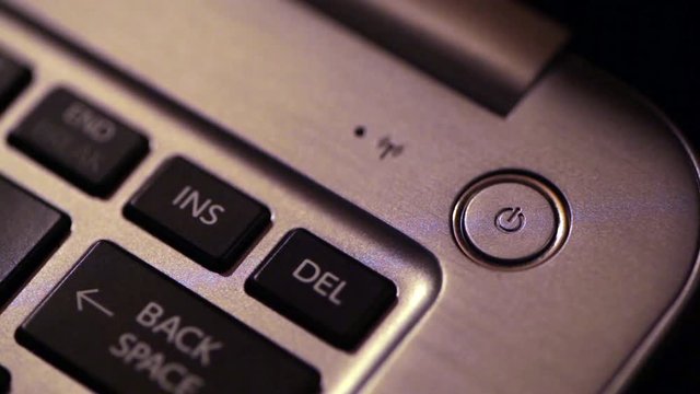Close up footage of a laptop power button.