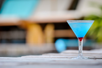 Frozen Blue Margarita Cocktail, blue cocktail on the wooden table, blurry background