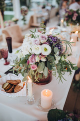 Bouquet of flowers and greenery is on the wedding table in the banquet area