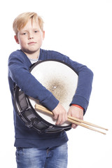 young blond boy holds drum against white background