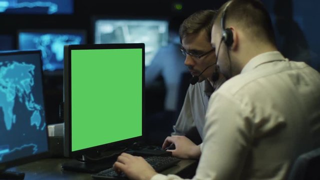 Concentrated Programmers Work on Personal Computers Located in a System Control Room. Computer has Green Screen. Shot on RED Cinema Camera in 4K (UHD).
