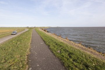 dike between meadow area and ijsselmeer in the netherlands