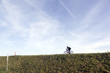 man on mountain bike on dutch dike in waterland