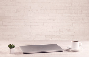 Office desk closeup with white brick wall