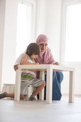 Arabic mother with little son learning in living room