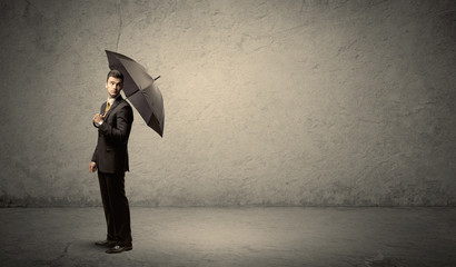 Handsome business man holding umbrella with copy space backgroun