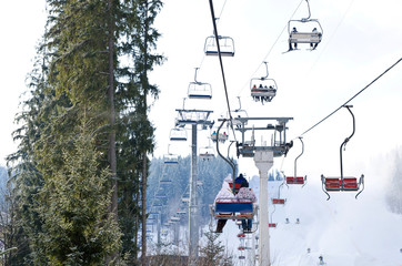 Cableway lift gondola cabins on winter snowy mountains backgroun