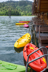 Colorful of kayak, canoe float on water, lake beside is house raft  with mountain in background