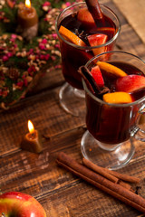 Mulled wine near candle with fruits and spices on wooden table. Christmas. Winter warming drink ...