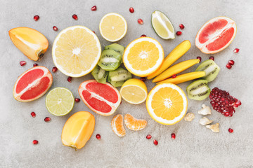 Various sliced citrus and other fruits on gray table