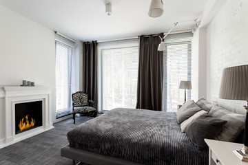 Grey bedroom with fireplace and bed
