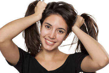 Fototapeta premium portrait of happy girl who holds her hair in two tails