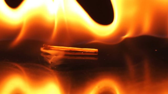 Falling matchstick lights a flammable liquid, Slow motion
