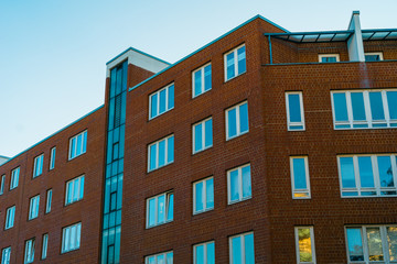 Fototapeta na wymiar brick office building with orange facade and blue windows