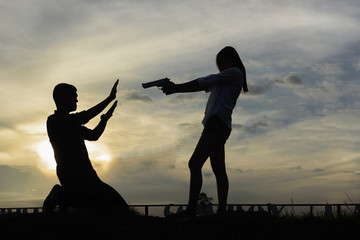 silhouette woman pointing a gun. Mafia girl shooting at someone - 129797458