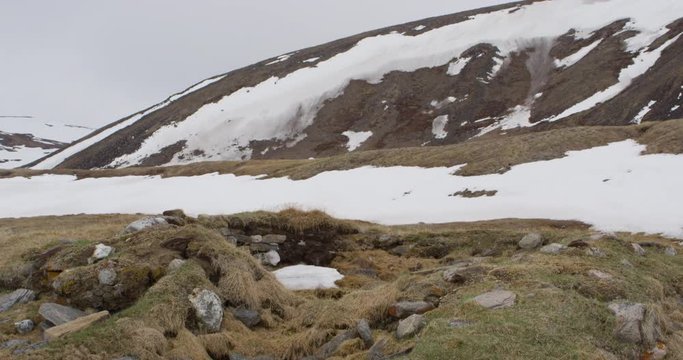 Tilt up of thule ruin of old house in snowy mountain tundra