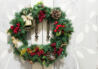 Fototapeta na wymiar Christmas wreath with angel and bells on a rustic background.
