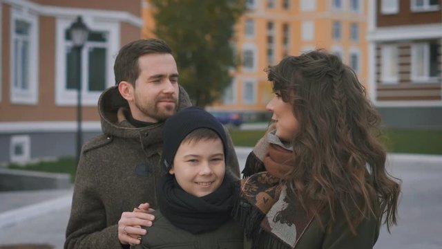 Happy family on a photo shoot. Mother, father and son. They pose for the camera. The family has an excellent mood. They want to capture forever in their memories and photos on this sunny