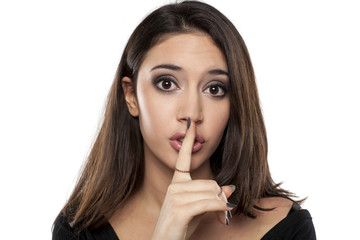 beautiful young woman with a finger in front of her lips. concept for silence