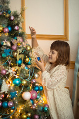 Girl kid in dress with  bear around  Christmas tree,  real inter