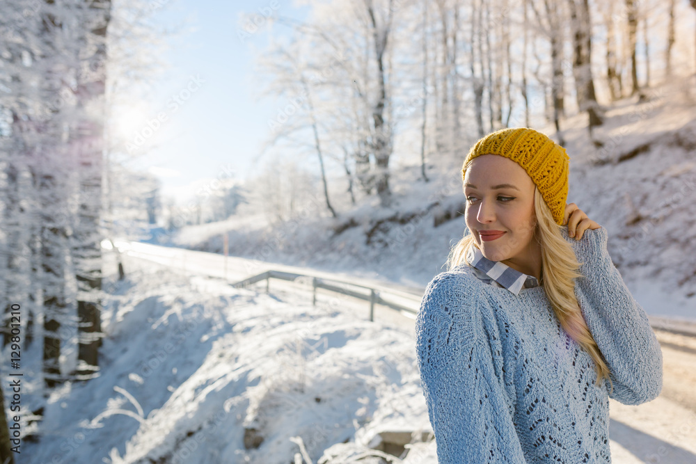 Wall mural Beautiful young woman in her winter warm clothing. Happy woman h