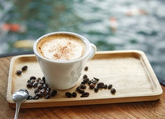 Cup of coffee on the table. A wooden tray.