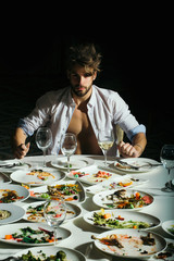 Handsome man eats at table