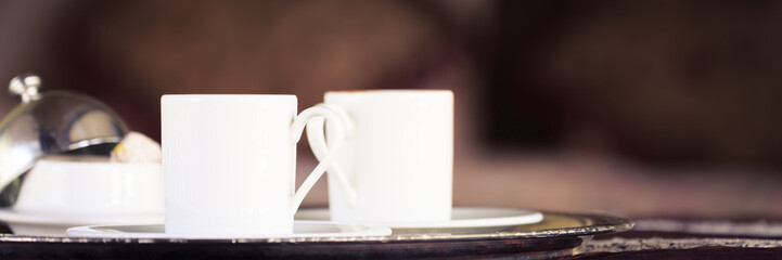 Two turkish coffee cups with oriental canopy bed at the backgrou