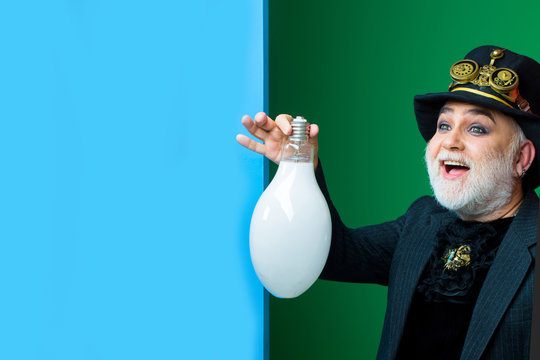 smiling man holds light bulb