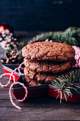 Homemade christmas chocolate cookies on wooden table background. Christmas baking with festive decoration