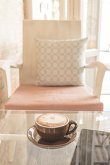 A cup of coffee latte on the table in coffee shop, Vintage filter effect.