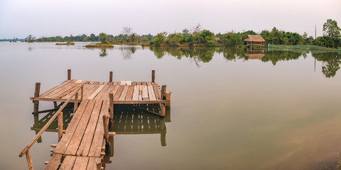 Panorama landscape with wooden pier on the Troav Kot Lake, Cambodia. Sunset in pastel colors. © sonatalitravel