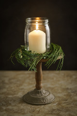 Christmas candle decoration with fir green and eucalyptus on a wooden stand