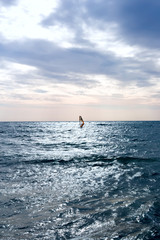 Group of windsurfers on boards in wavy sea