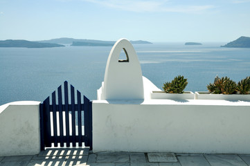 blue gate wicket and white fence. Mediterranean sea and Santorini caldera  on the background....