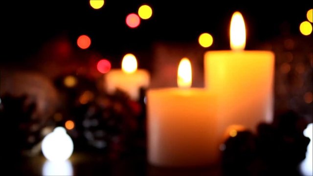 Blurred Christmas decoration background with burning candles. Burning white candles