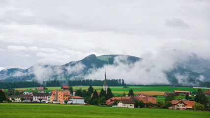 Fototapeta na wymiar Church and Charmey village on Prealps in Gruyere Fribourg Switzerland