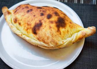 Pizza calzone on white plate