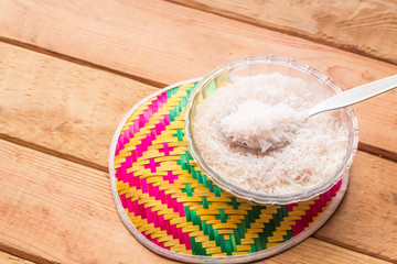 Rice in bowl and colorful tray on wooden table.
