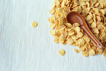 Cornflakes in a spoon on cornflakes background. Close-up.