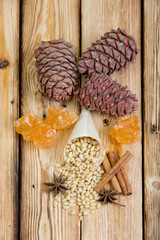 Cedar nuts, rolls of cinnamon, grape sugar and star anise on wooden table